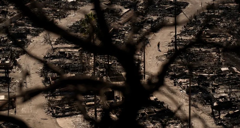 Seorang petugas pemadam kebakaran berjalan di sepanjang jalan di sebuah komunitas yang dilanda kebakaran setelah kebakaran Palisades di lingkungan Pacific Palisades, Los Angeles, Senin, 13 Januari 2025 [John Locher / AP]